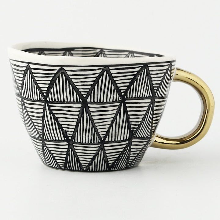 Cup with abstract geometric pattern and gold handle
