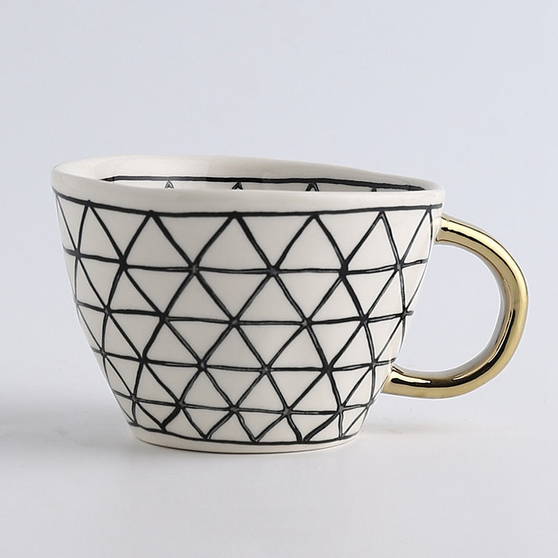 Cup with abstract geometric pattern and gold handle