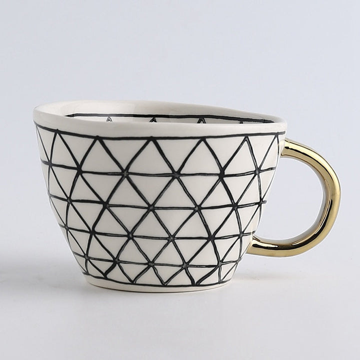 Cup with abstract geometric pattern and gold handle