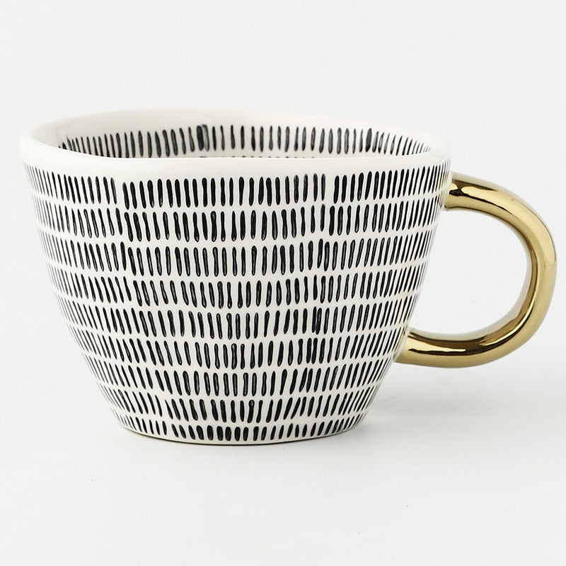 Cup with abstract geometric pattern and gold handle