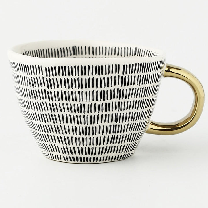 Cup with abstract geometric pattern and gold handle