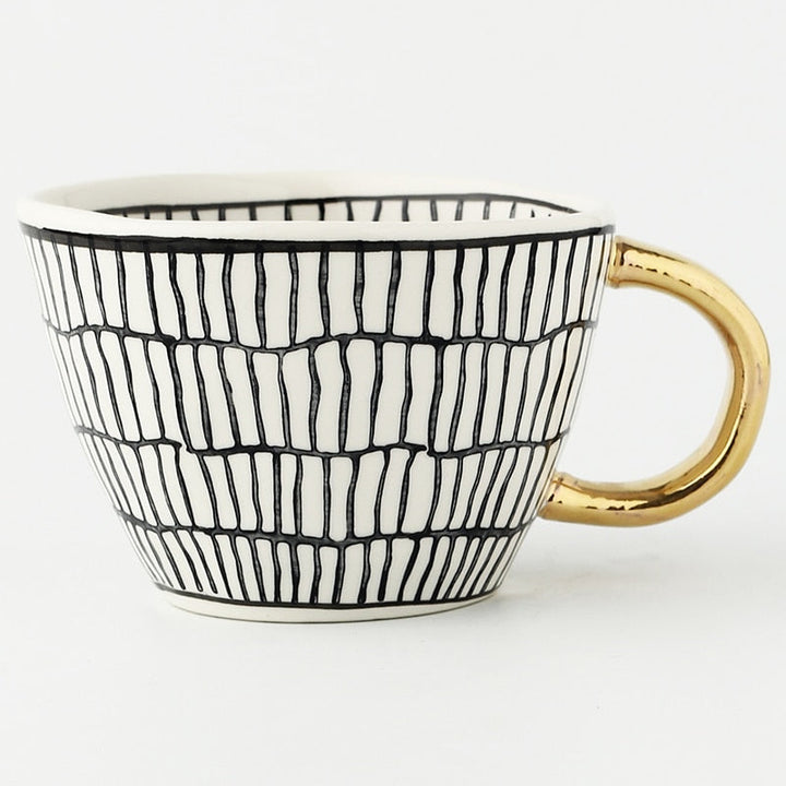 Cup with abstract geometric pattern and gold handle