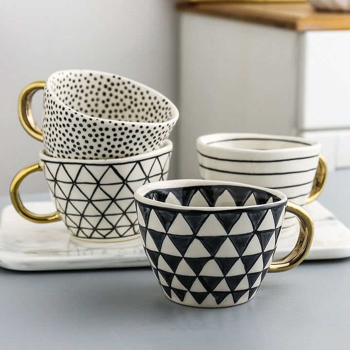 Cup with abstract geometric pattern and gold handle