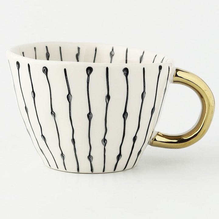 Cup with abstract geometric pattern and gold handle