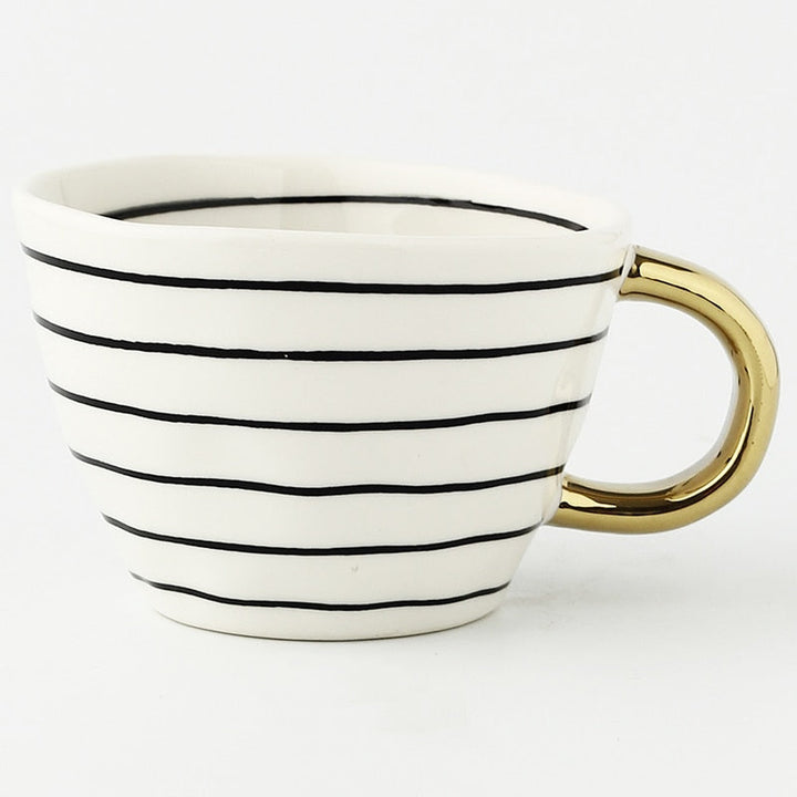 Cup with abstract geometric pattern and gold handle