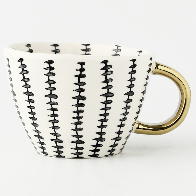 Cup with abstract geometric pattern and gold handle