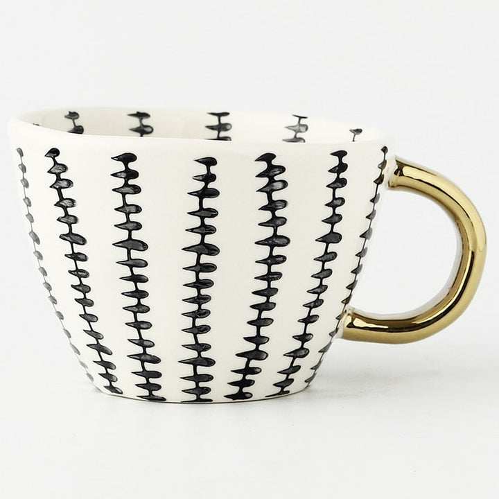 Cup with abstract geometric pattern and gold handle