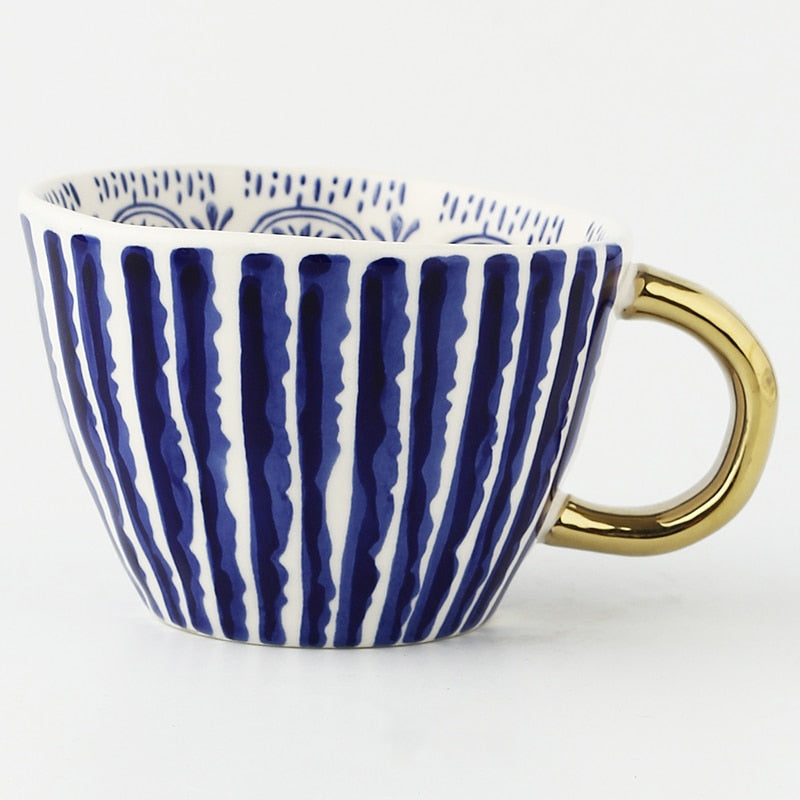 Cup with abstract geometric pattern and gold handle