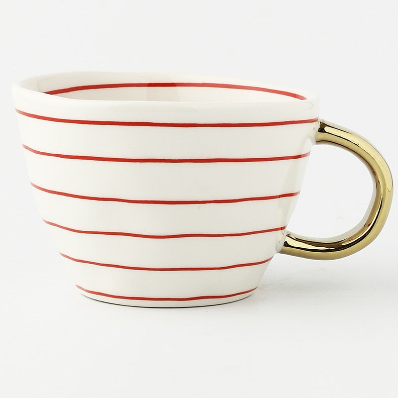 Cup with abstract geometric pattern and gold handle