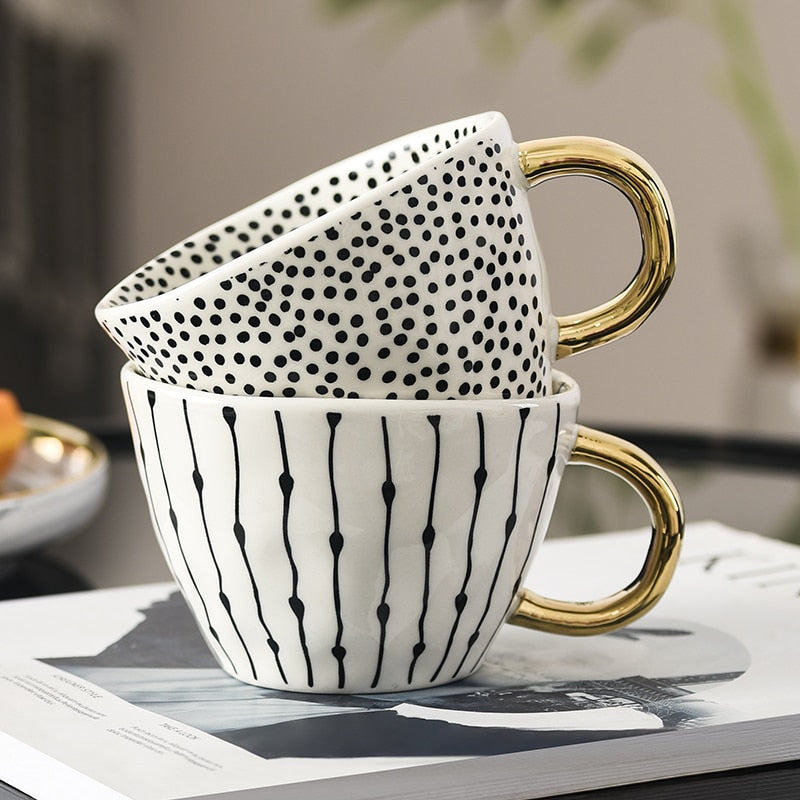 Cup with abstract geometric pattern and gold handle