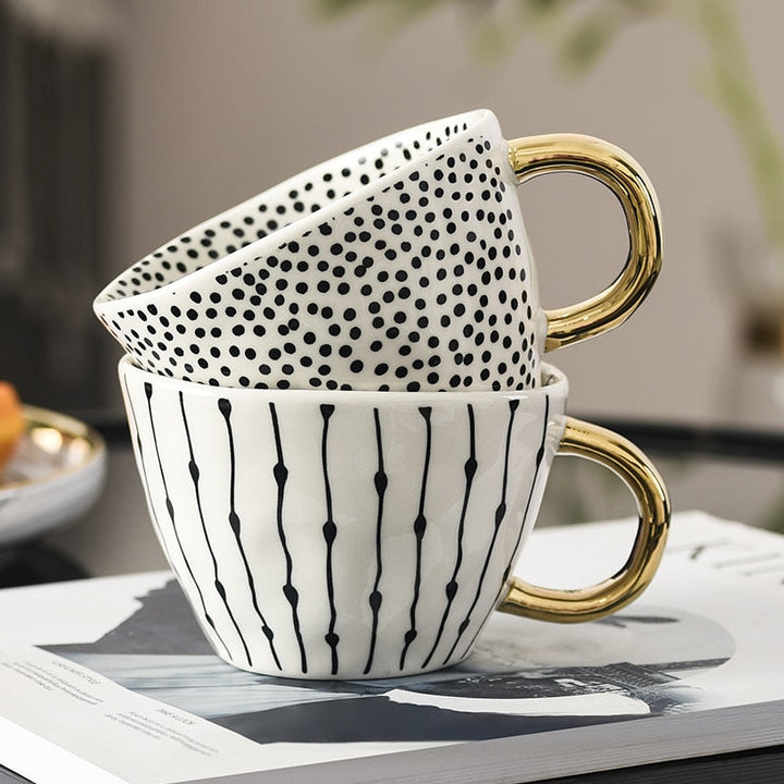 Cup with abstract geometric pattern and gold handle
