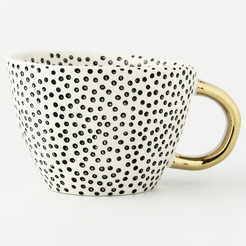 Cup with abstract geometric pattern and gold handle