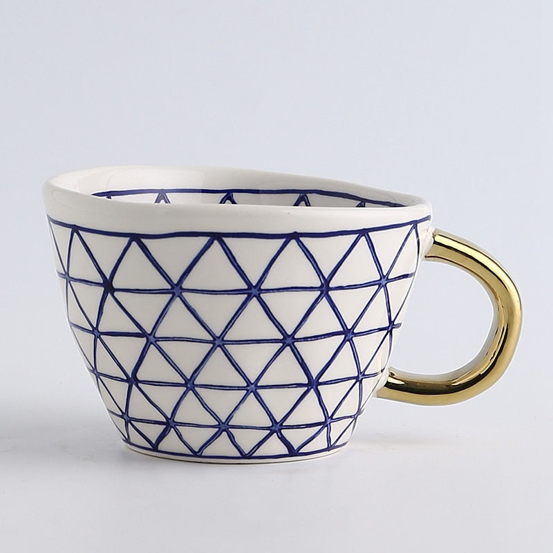 Cup with abstract geometric pattern and gold handle