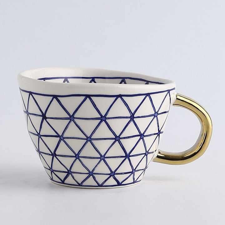 Cup with abstract geometric pattern and gold handle