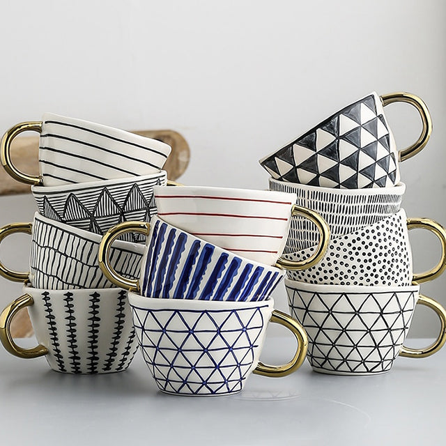 Cup with abstract geometric pattern and gold handle
