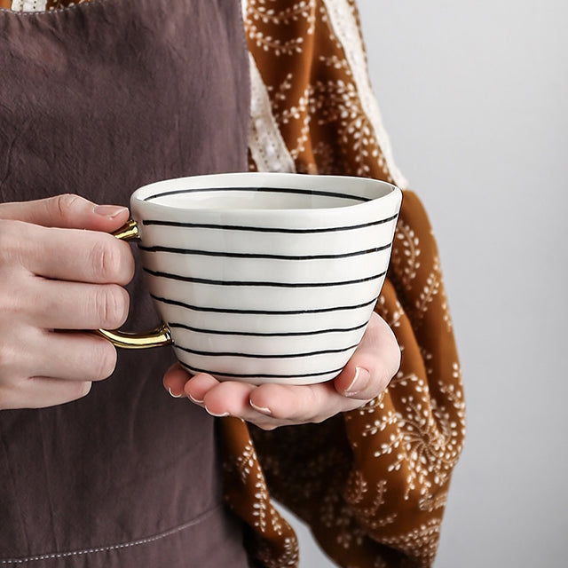Cup with abstract geometric pattern and gold handle